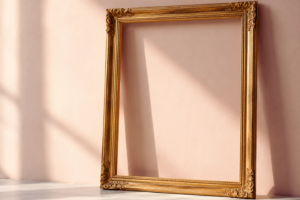 Cornice dorata vuota appoggiata a una parete rosa, simbolo delle aspettative e degli stereotipi sociali.